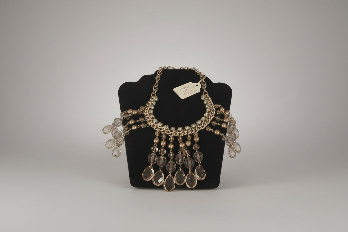 Jewelry display with a necklace and bracelet on a mannequin head in a store window.