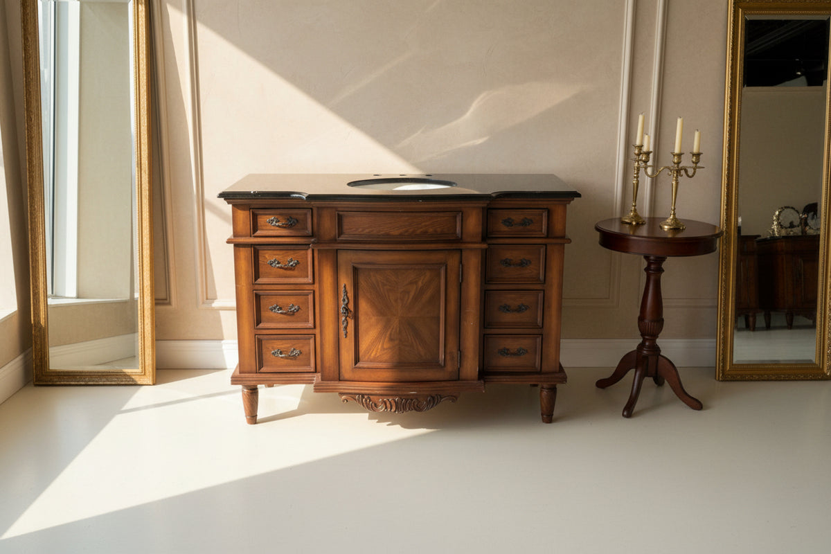 Wooden bathroom vanity with black countertop and sink
