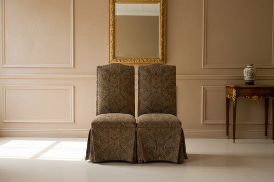 Two patterned chairs in a cluttered room with various items.